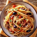 A plate of Spaghetti Puttanesca with olives, capers, and a rustic setting